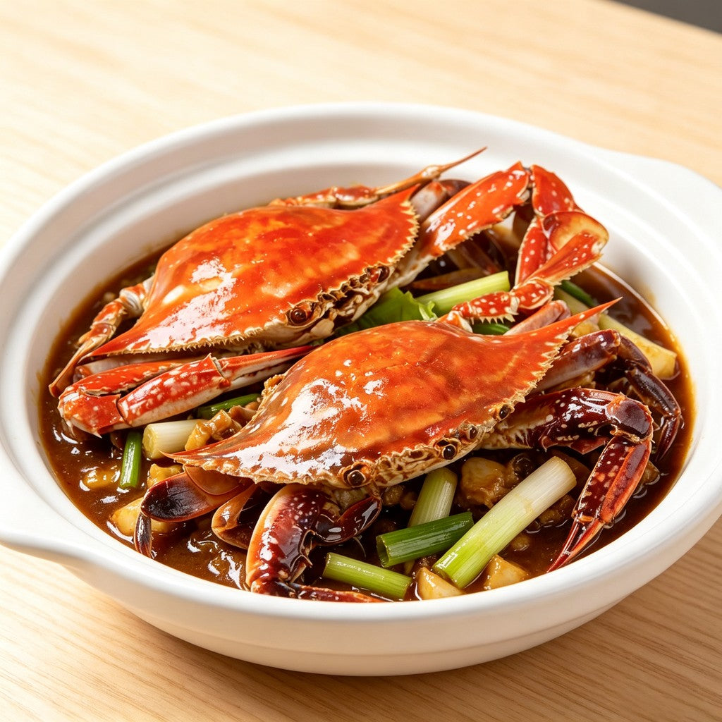 Cooked swimming crab sections in a bowl with savoury sauce and spring onion